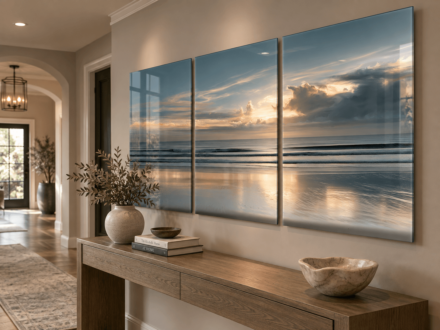 Angled view of coastal sunset glass triptych displayed above a wooden console table in an entryway