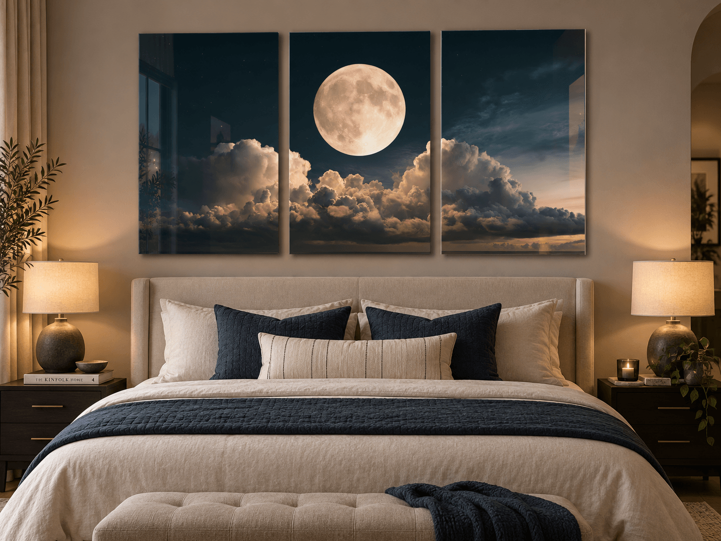 Full moon triptych glass wall art glowing above a beige bed with navy pillows in a bedroom