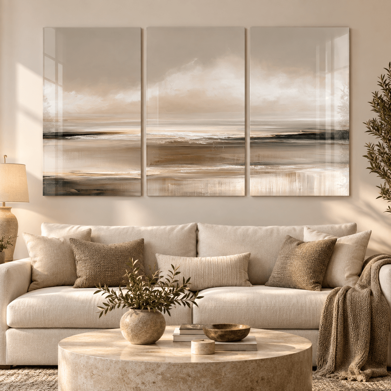 Close-up of the coastal triptych glass panels above a cream sofa with a round travertine table